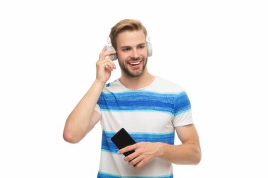 Beyazda izole edilmiş kablosuz kulaklıklı modern telefon. Milenyum adamı kulaklıkla müzik dinliyor. Telefon kullanan kulaklıklı bir adam. Z jenerasyonu elemanı eğitim ya da müzik için telefon uygulaması kullanıyor.