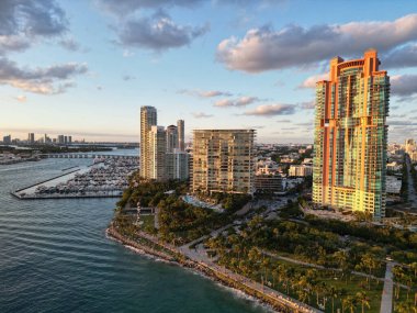 Akşam günbatımında şehir silüeti. Liman kenti havası. Miami Güney Sahili. Gün batımında gökdelen şehir manzarasında havadan panoramik manzara. Günbatımı şehir havası. Miami, Florida 'da lüks bir gökdelen.