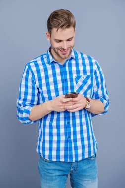 İş mesajlaşması. Modern mobil iş iletişimi. Genç adam telefonda mesajlaşıyor. Akıllı telefon sohbetleri. Akıllı telefon kullanımı. Telefonda mesajlaşan adam Grey 'i izole etti. Sohbet sırasında mesajlaşma.