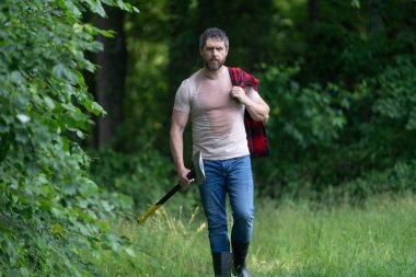 Ormanda baltayla oduncu. Keresteci gömlekli ve baltası ağır. Ormanda güçlü bir adam. Oduncu ormanda balta taşıyor. Oduncu çok çalıştıktan sonra terliyor. Baltalı olgun bir adam..