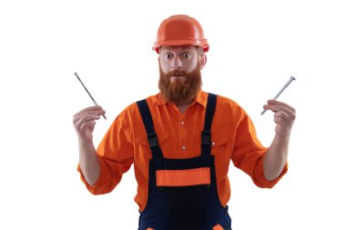 Adam çekiç çivisi tutuyor. Marangozluk tamir ve çekiç. Üniformalı tamircinin çivisi var. Sakallı marangoz çivi tutar. Marangoz, beyaz çiviyle tamir ediyor. Tamirci. DIY ahşap atölyesi.