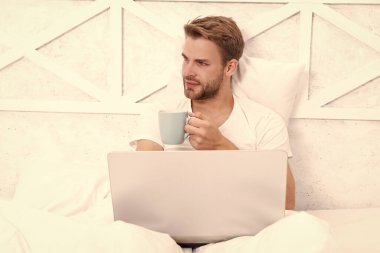 Hafta sonu işkolik. Sabah kahvesi hazır. Yatakta serbest çalışan. Milenyum adamı evde dizüstü bilgisayarda çalışıyor. Adam yatakta yatıp dizüstü bilgisayarla internette sörf yapıyor. Bilgisayarda evden çalış. Rahat çocuk..