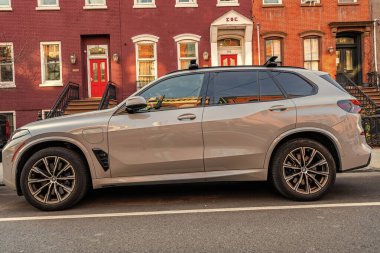 New York City, USA - March 15, 2024: BMW X5 luxury automobile car parked outdoor, side view. clipart