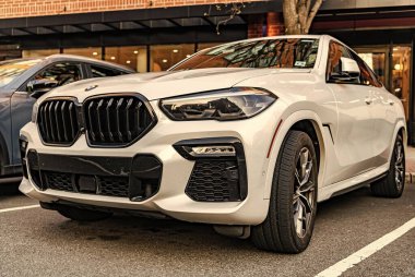 New York City, ABD - 15 Mart 2024: BMW X6 modern beyaz araba, köşedeki manzara.