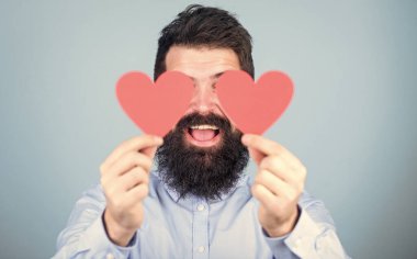 Expressing his love. Sexy valentine man covering eyes with love cards. Hipster with small hearts. Bearded man holding red hearts. Happy valentines day. Spreading more love.
