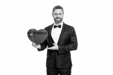 Stüdyoda sevgililer günü hediyesi sunan bir adam. Smokinli adam sevgililer günü kutusunu tutuyor. Smokinli bir adam sevgililer günü için hediye tutuyor. Sevgililer Günü hediyesi olan smokinli adam beyaz arka planda izole edilmiş..