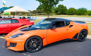 Chicago, Illinois, USA - September 08, 2024: 2005 2021 Lotus Evora GT 400 sportscar vehicle, corner view. Orange sportscar. Modern 2021 Lotus Evora GT car. 2021 Lotus Evora GT at Chicago clipart