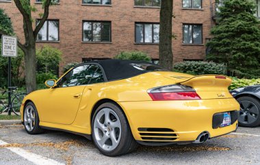 Chicago, Illinois - 29 Eylül 2024: Porsche 911 Turbo Carrera S sarı renk. Porsche 911 Turbo Carrera S yola park etti. ön görünüm
