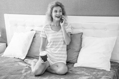 Kahveli gülümseyen kadın telefonda konuşuyor. Evde telefonla konuşan bir kadın. Kadının evinde telefon konuşması..