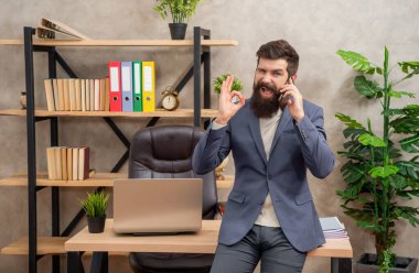 Bu konuda anlaştık. Ofiste cep telefonuyla konuşan mutlu bir adam. - Anlaştık. İyi niyet göstergesi olarak kabul ediyorum. İş görüşmesi. Tamam..