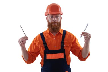 Tamirci. Adam çekiç çivisi tutuyor. Marangozluk tamir ve çekiç. Üniformalı tamircinin çivisi var. Sakallı marangoz çivi tutar. Marangoz, beyaz çiviyle tamir ediyor. Mobilya yapmak.