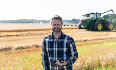 Tablet çekli İspanyol çiftçi. Ekin hasadı. Tarlada tableti olan çiftçi tarımcı adam. Modern tarımın teknolojisi. Tarlada tabletle çalışan çiftçi. Yenilik alanı.