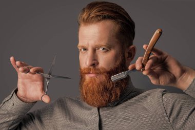 Berber saç stili bir adamın yüzü. Berberin stüdyoda saç stili var. Berber adam makası tut. Erkek saç stili kavramı. Modern saç stili olan adam gri arka planda izole edilmiş..