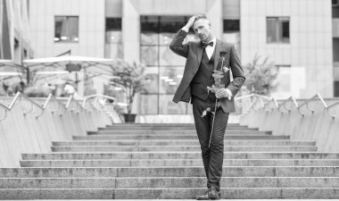 elegant man bridegroom in tuxedo. bridegroom in tuxedo bowtie outdoor. handsome bridegroom with red rose.