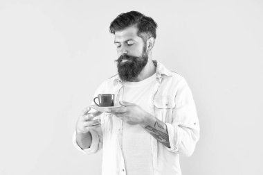 Sakallı adam sabah kahvesini sarı arka planda içer, kahve fincanı....