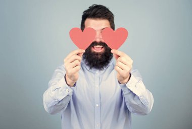 İçindeki duyguları açıklıyor. Sakallı adam kırmızı kalplerle gözlerini kapatıyor. Hippi küçük kalpler tutuyor. Kalp şeklinde süslemeleri olan seksi bir sevgililer günü erkeği. Sevgililer günün kutlu olsun. Aşkın bayramı.