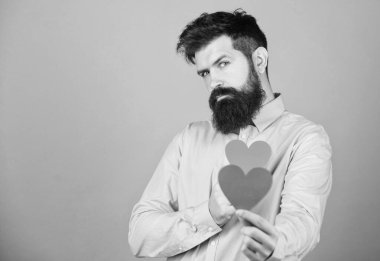 Celebrate love. Guy attractive with beard and mustache in romantic mood. Feeling love. Dating and relations concept. Happy in love. Falling in love. Man bearded hipster with heart valentine card.
