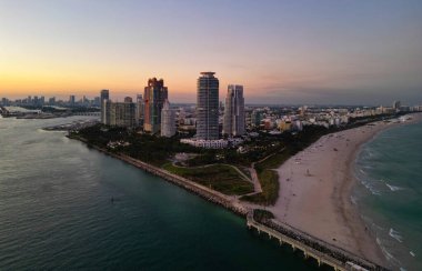 Gece şehri hava manzarası. Miami, Florida 'da lüks bir gökdelen. Akşam günbatımında şehir silüeti. Havadan şehir manzarası. Gece Miami South plajı. İyi akşamlar güzellik. Geceleri gökdelen şehir manzarasında hava manzarası.