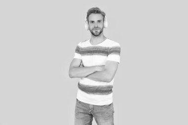 Gülümseyen adam rahatlar ve stüdyoda müzik dinler. Adam müzik dinlemek için kablosuz kulaklıklarını kullanıyor. Adam dinliyor ve canlı müzikten hoşlanıyor. Adam sarı kulaklıkla müzik dinliyor..