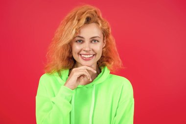 Moda kıyafetleri ve tarzı. Kazaklı beyaz bir kadın. Sıradan bir yaşam tarzı. Havalı kapüşonlu giyen kızıl saçlı kız. Pembe üzerine izole edilmiş şık bir kadın. Hareketli moda kız kapüşonlu giyer. Moda simgesi.