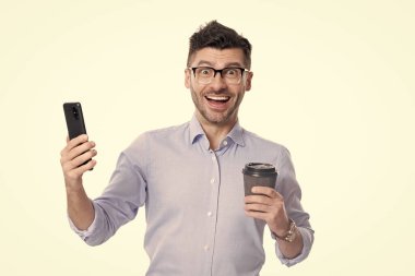 Kahveli bir iş adamı beyazın üstüne izole edilmiş. Kahve molası. İş iletişimi. Adam iş konuşuyor. Telefon var. İş adamı iletişim için telefonu kullanıyor. Profesyonel yazışmalar.