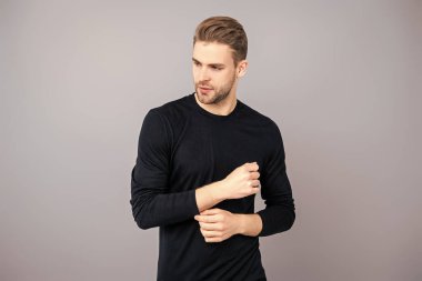 Beyazlı genç bir adam gri yolda izole edilmiş. Kendine güvenen adam portresi. Erkeklerin cilt bakımı. Erkek derisi. Adamın şık bir saç kesimi var. Moda saç stili olan bir adam. Sıradan erkek tarzı. Manyetik Yakışıklılık.