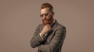 Erkek giyim smokinli kızıl saçlı adam. Erkekler şık erkek kıyafetleri giyer. Resmi takım elbiseli sakallı adamın zarafeti. Smokinli erkek giysili adam Griler 'de izole edilmiş. Sofistike zarafet.