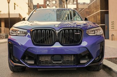 New York City, USA - March 25, 2024: BMW X3 M vibrant blue color car parked outdoor, front view. clipart