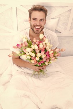 Kadınlar günü çiçekleri olan mutlu bir adam. Kadınlar günü çiçek buketi olan bir adamın fotoğrafı. Kadınlar günü çiçekleri olan bir adam. Kadınlar günü çiçekleri olan romantik bir adam..
