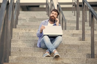 Adamın dış mekanda görüntülü iletişimi var. Adamın dışarıda çevrimiçi video bağlantısı var. Adamın merdivenlerde online video bağlantısı var. Adamın online video iletişimi var.