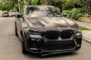 New York City, ABD - 26 Ağustos 2023: BMW X6 SUV araç geçişi, ön manzara.