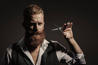 Siyah sakallı hippi berber. Berberdeki kuaförden sakal kesimi. Saç keserken makas kullanan yakışıklı berber. Modern berber saç kesimi.