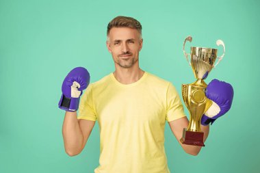 Spor başarısı ve zafer. Şampiyonlar kupası. Boks sporunu kazanan sporcu. Başarılı bir spor. Olgun boksör şampiyonu. Başarıyı kutluyoruz. Boks şampiyonu. Kendisiyle gurur duyuyor..