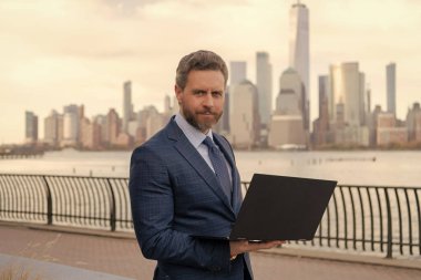 New York 'ta serbest çalışan bir iş adamı. İnternette çalışan bir iş adamı. İş adamı dışarıda bilgisayar ya da dizüstü bilgisayarda çalışmakla meşgul. Adam internet tarayıcısından iş e-postası ve sörf yolluyor. Piyasa talebi.