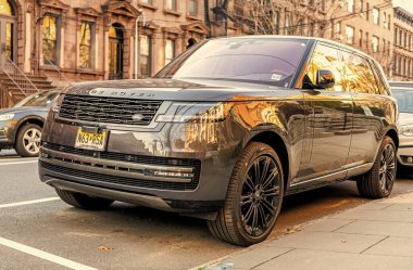 New York City, ABD - 15 Mart 2024: Land Rover Range Rover modern araba caddeye park edilmiş, köşe manzara.