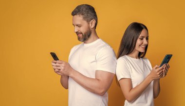 Kadın ve erkek akıllı telefon kullanıyor. Sohbet ve mesajlaşma. Bağlandı. Özel mesaj. SMS iletişimi. İnternette sohbet eden bir çift. Aile çiftlerinin mesafeli ilişkileri vardır. Pankart.