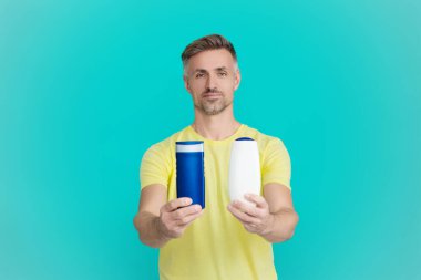 Adam şampuan kullanıyor. Olgun adam saç kremi kullanır. Tıraş losyonlu adam. Günlük alışkanlık ve kişisel bakım. Cilt güzellik kozmetiği. Şampuan ya da tıraş losyonu. Erkek kozmetik ürününü sunuyorum. Sağlıklı saçlar.