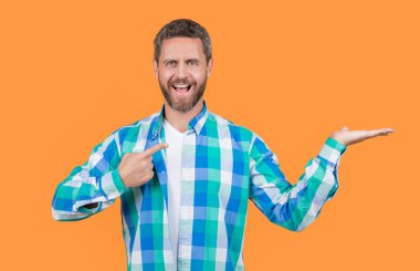 Sıradan giyinmiş, yönetmenlik yapan beyaz bir adam. Sarı arka planda, günlük gömlekli, sakallı, beyaz bir adam. Stüdyoda sıradan bir beyaz adam var. Beyaz adamın fotoğrafı. Kareli gömlek giy..