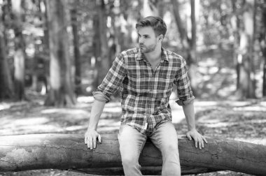 Kareli gömlekli genç yakışıklı adam dışarıda dinleniyor..