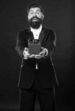 Smokinli, papyon takan, siyah arka planda, kutulu mutlu bir adam. Sevgililer Günü.