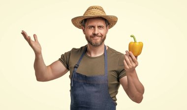 Önlüklü, şapkalı, biberli, beyaz tenli bir adam. hasat ediliyor.