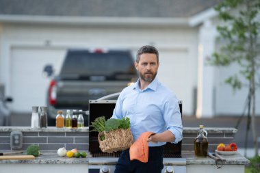 Şef mutfakta çiğ balık somonu pişirdi. Restoran menüsü. İspanyol şef sebze kabuklu balık filetosu tutuyor. Somon filetosu. Arka bahçede ızgarada kızarmış balık filetosu. Izgara ve mangal..