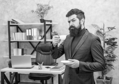Kendine güvenen sakallı iş adamı ofiste fotokopi odası ve iş yeri olan kahve içiyor..