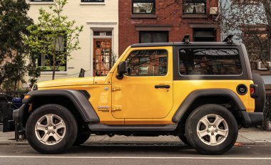 New York City, USA - April 01, 2024: 2020 Jeep Wrangler Sport S yellow car parked outdoor, side view. clipart