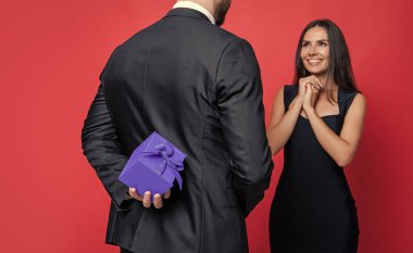 Hediyeli romantik evlenme teklifi. Hediye. Erkek kadına evlenme teklif ediyor. Erkek, sevgililer günü için kadınlara hediye kutusu verir. Sevgililer günün kutlu olsun. Aşık çift kırmızıda izole edilmiş. Teklif anı.