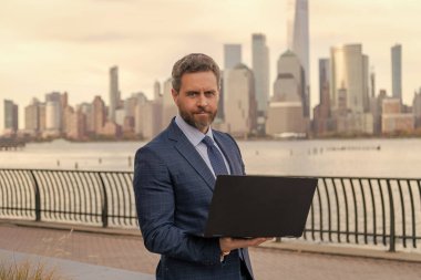 Adam internet tarayıcısından iş e-postası ve sörf yolluyor. New York 'ta serbest çalışan bir iş adamı. İnternette çalışan bir iş adamı. İş adamı dışarıda dizüstü bilgisayarla çalışıyor. Müşteri memnuniyetini arttır.