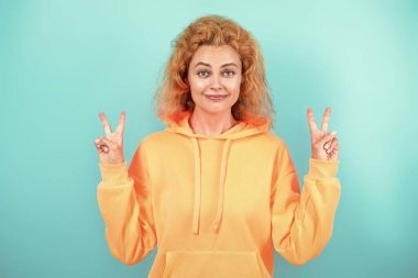 Şık kapüşonlu kızıl saçlı kız. Sıradan kapüşonlu, şık, beyaz bir kadın. Modayla ilgilenen kız modaya uygun ve parlak görünüyor. Mavi üzerine kapüşonlu giyen kadın. Moda modeli. Kapüşonlu.