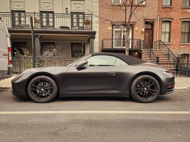 New York City, USA - February 10, 2024: Porsche 911 Carrera 4s cabriolet black car, side view. clipart