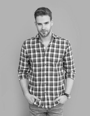 Gri arka planda kareli gömlekli şık bir adam izole edilmiş. Şık, rahat gömlekli bir adam. Stüdyoda stil sahibi bir adam. Kirli sakalı olan beyaz bir adam..