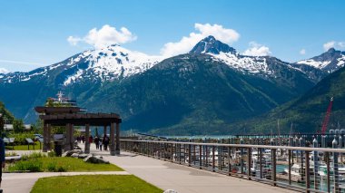 Skagway, Alaska, ABD - 07 Temmuz 2019: küçük tekne limanı. Karlı tepeleri olan dağ manzarası. Alaska manzarası, Skagway. Dağ kadar küçük tekne limanı olan manzara..